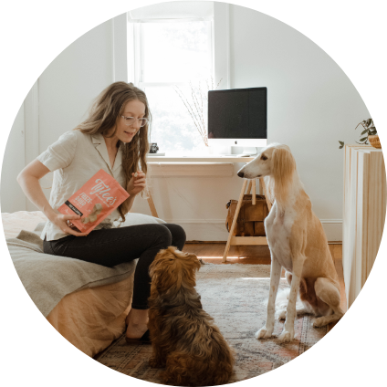 Une fille avec deux chiens dans sa chambre.